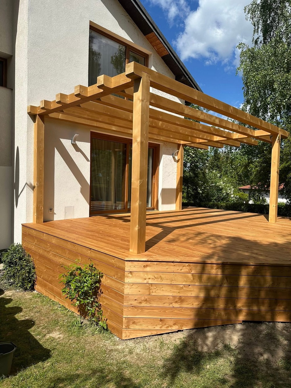 Nowoczesna pergola z drewna dopasowana do ogrodu i elewacji domu