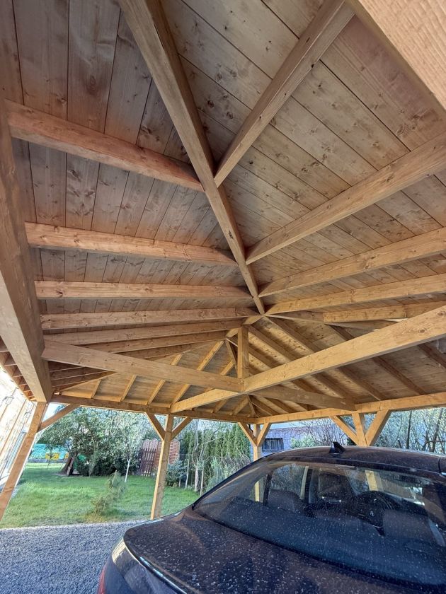 Drewniana konstrukcja carportu przy podjeździe na posesji